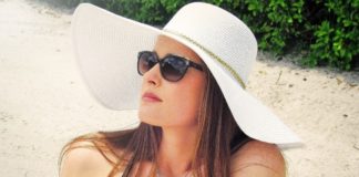woman on beach wearing hat and sunglasses